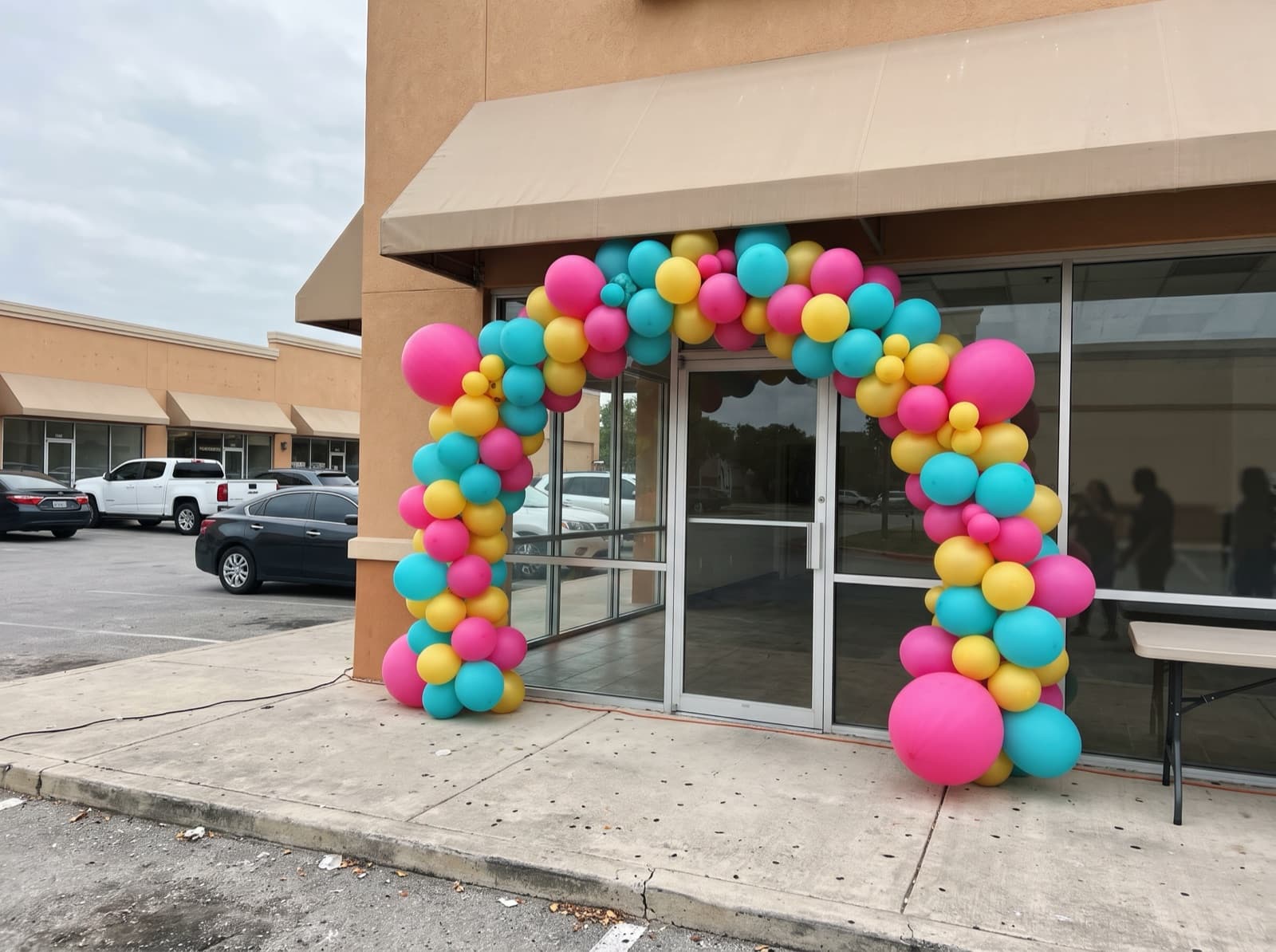 Large balloon arch in Fiesta colors over a storefront entrance