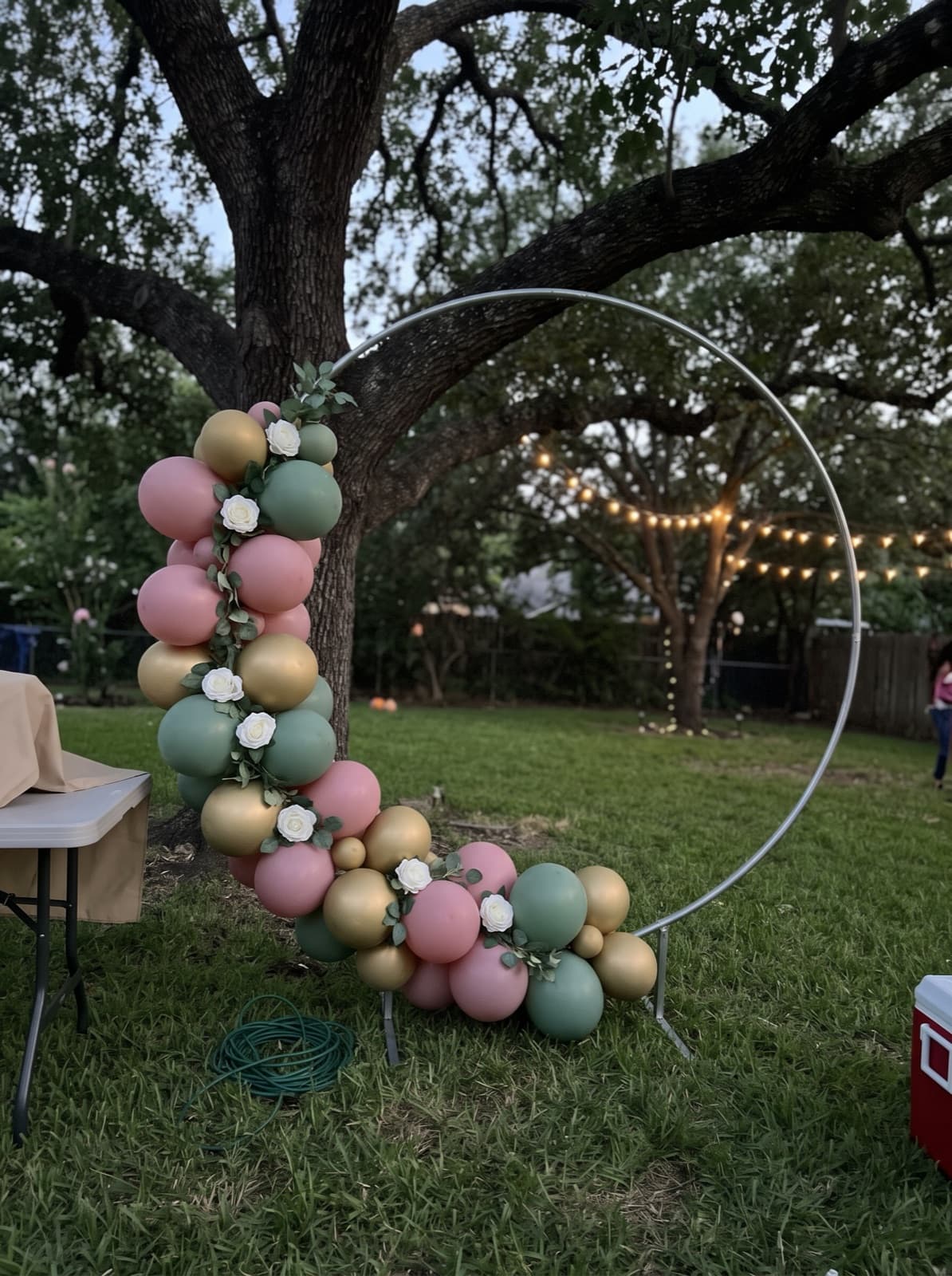 Balloon hoop backdrop with florals under an oak tree