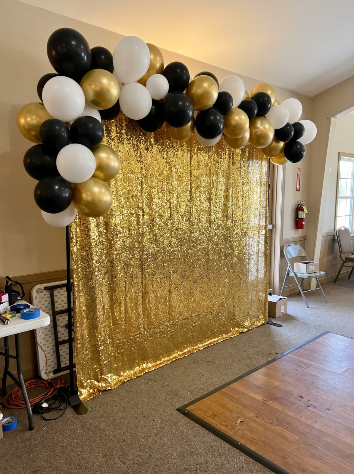 Gold shimmer wall backdrop with a balloon garland