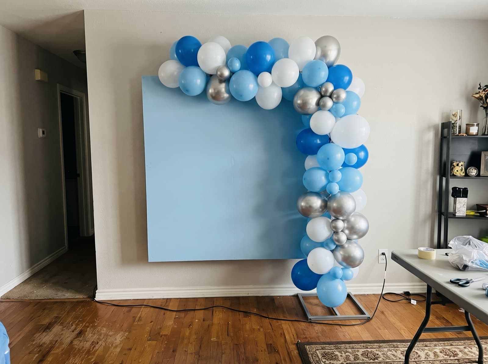Square backdrop with a blue and silver garland up one side