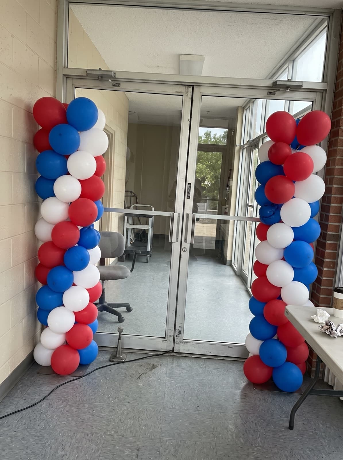 Red, white and blue spiral balloon columns at an office entrance