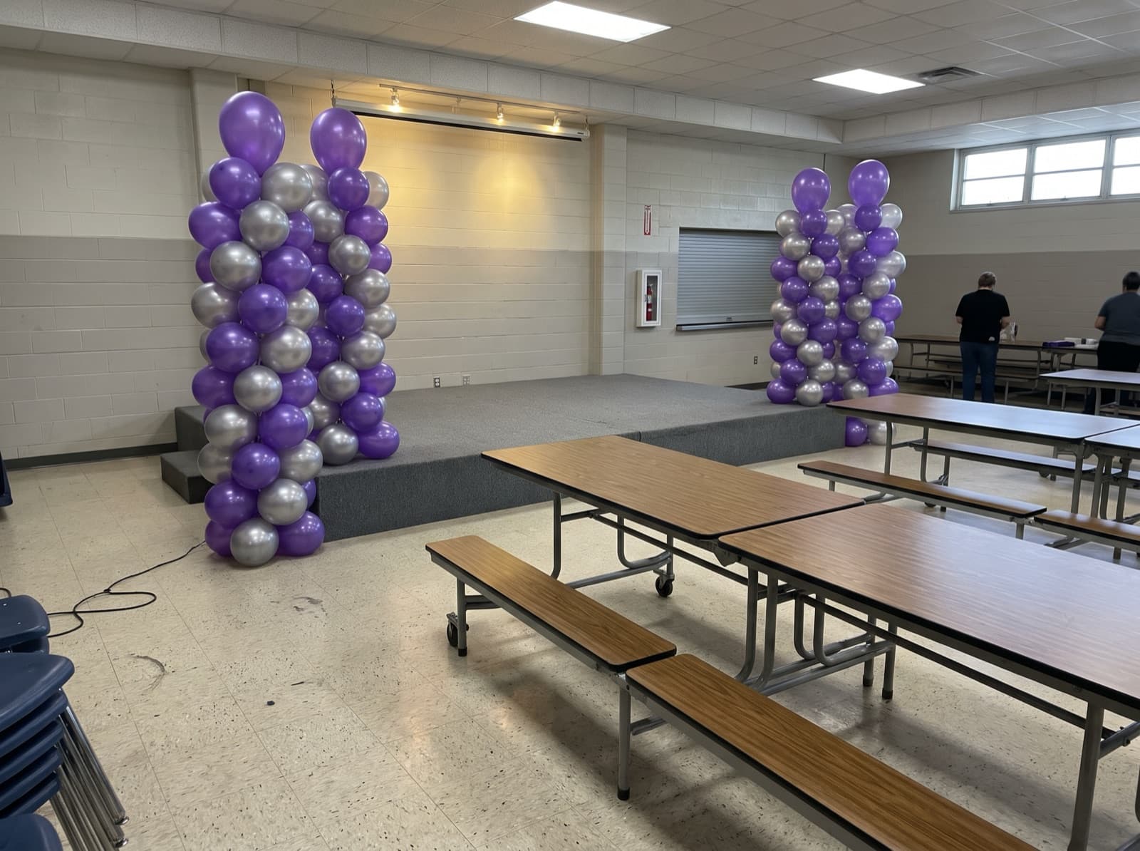 Tall balloon columns on each side of a school stage
