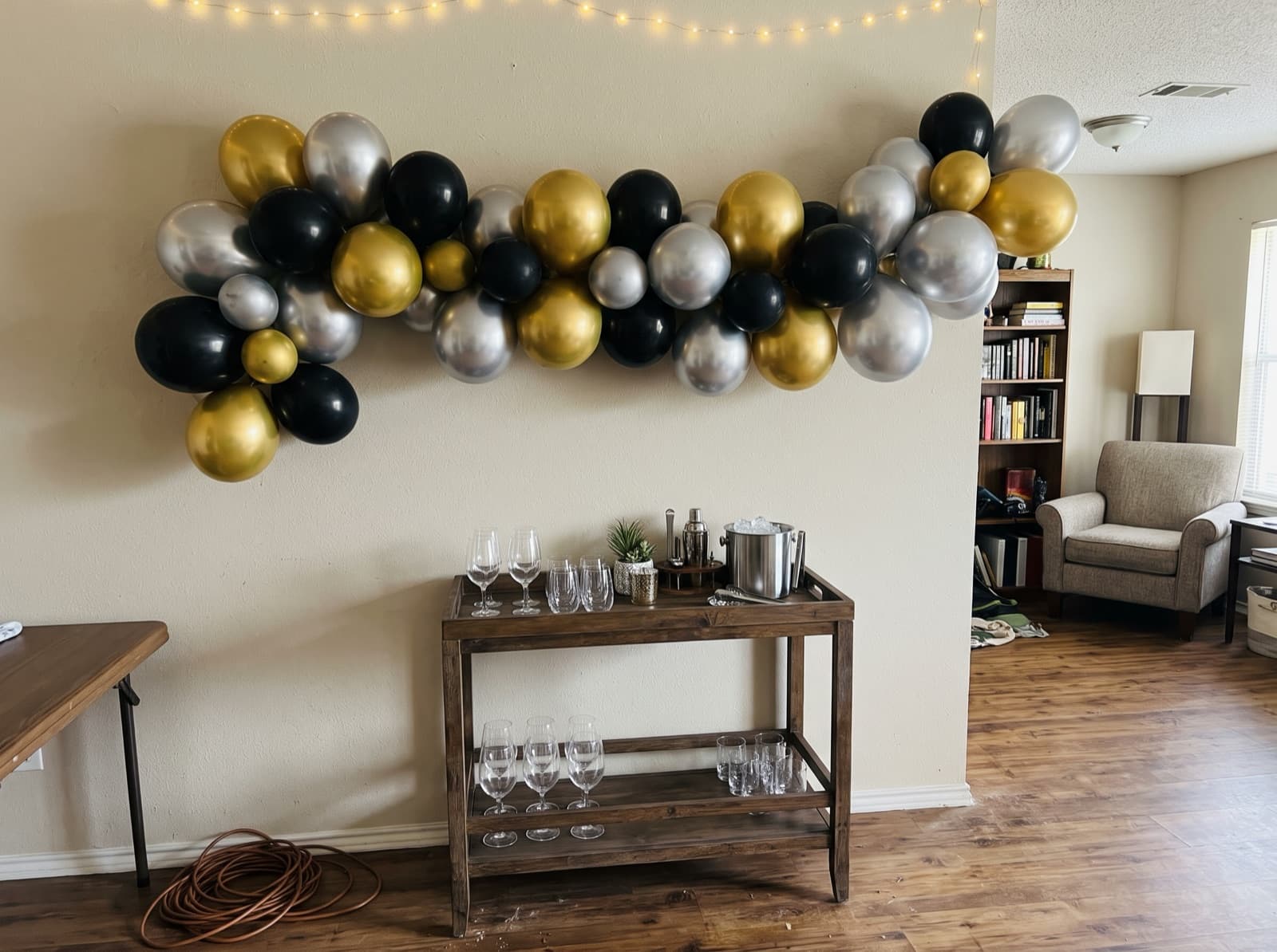 Chrome gold and silver balloon garland over a bar cart