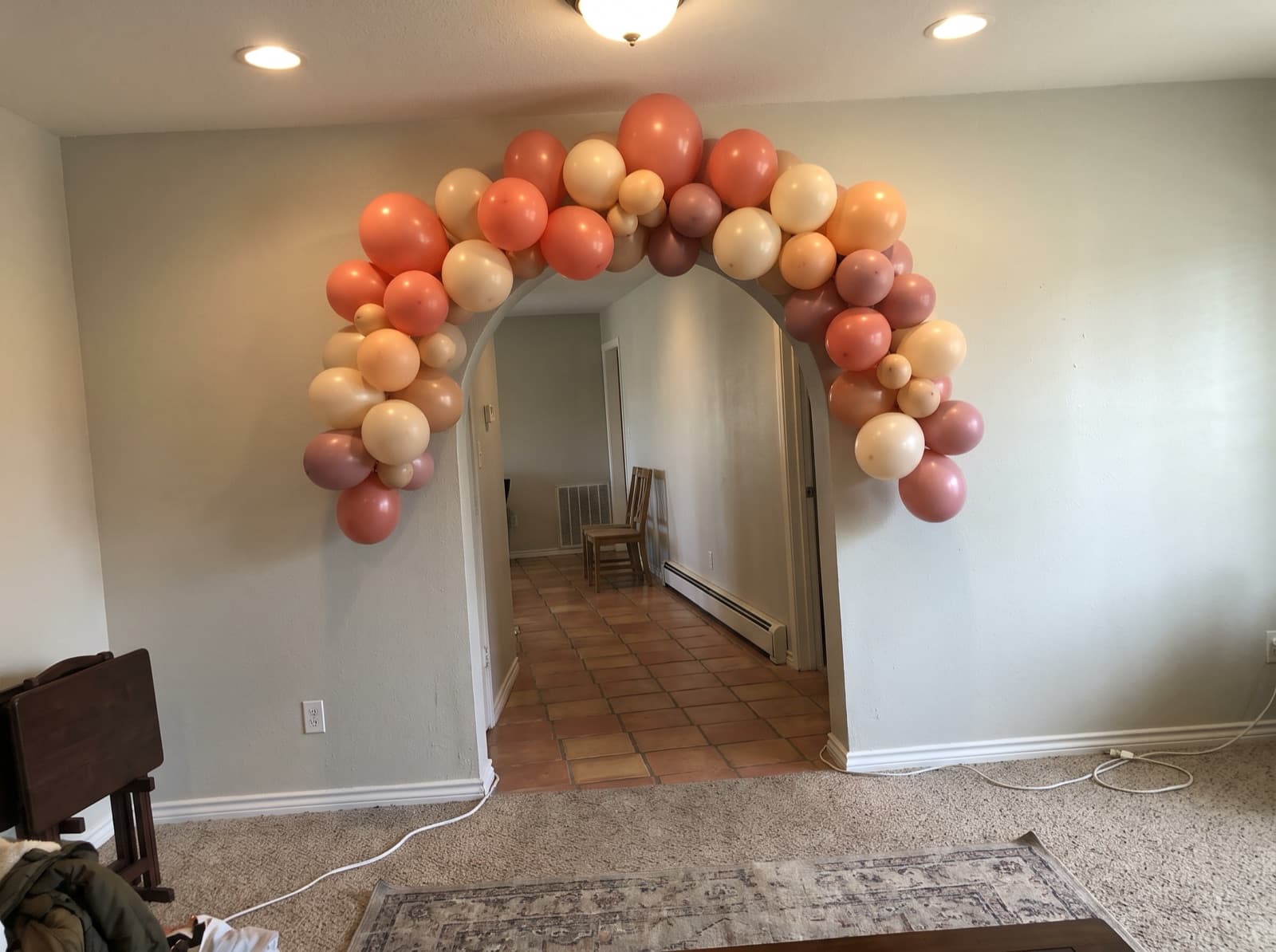 Organic balloon garland around a rounded stucco archway