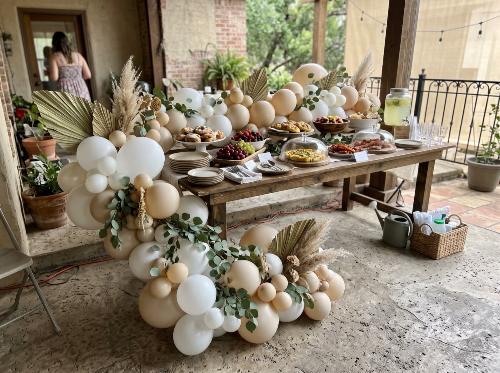Sand and pearl balloon garland with eucalyptus and dried palm along a buffet