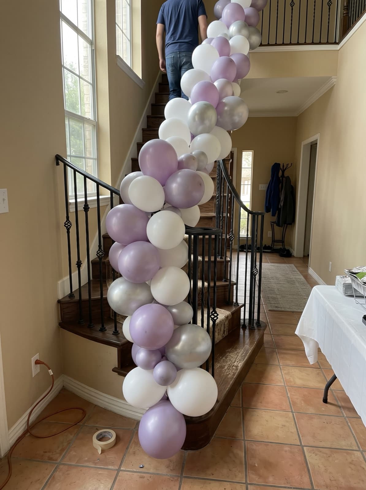 Balloon garland running down a wrought-iron staircase railing