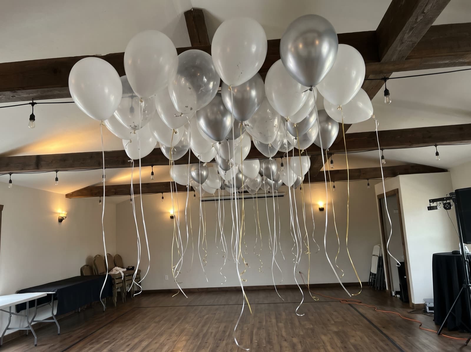Balloon ceiling of white, clear and silver balloons over a dance floor