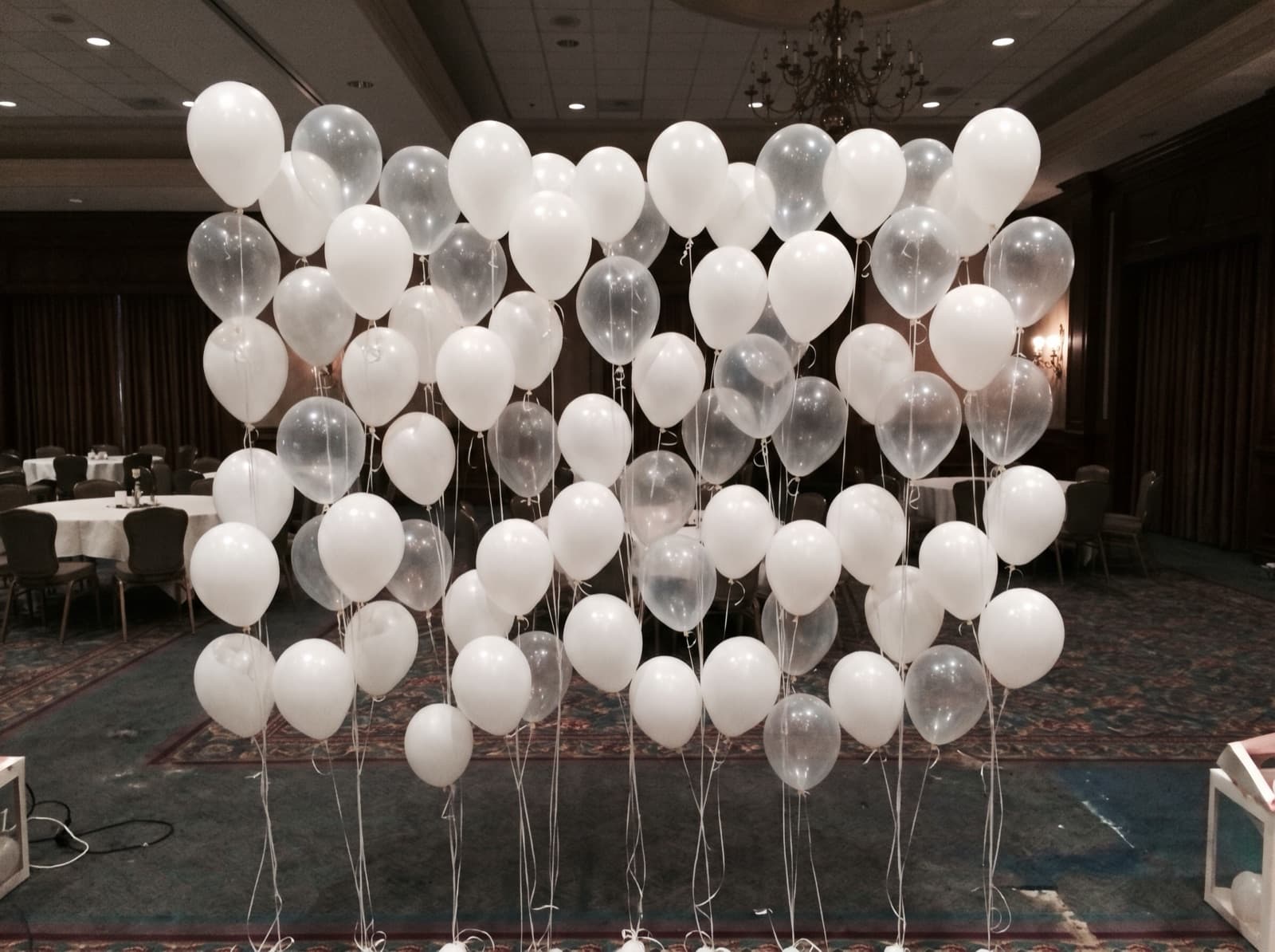 Floating helium balloon wall with ribbons in a hotel ballroom