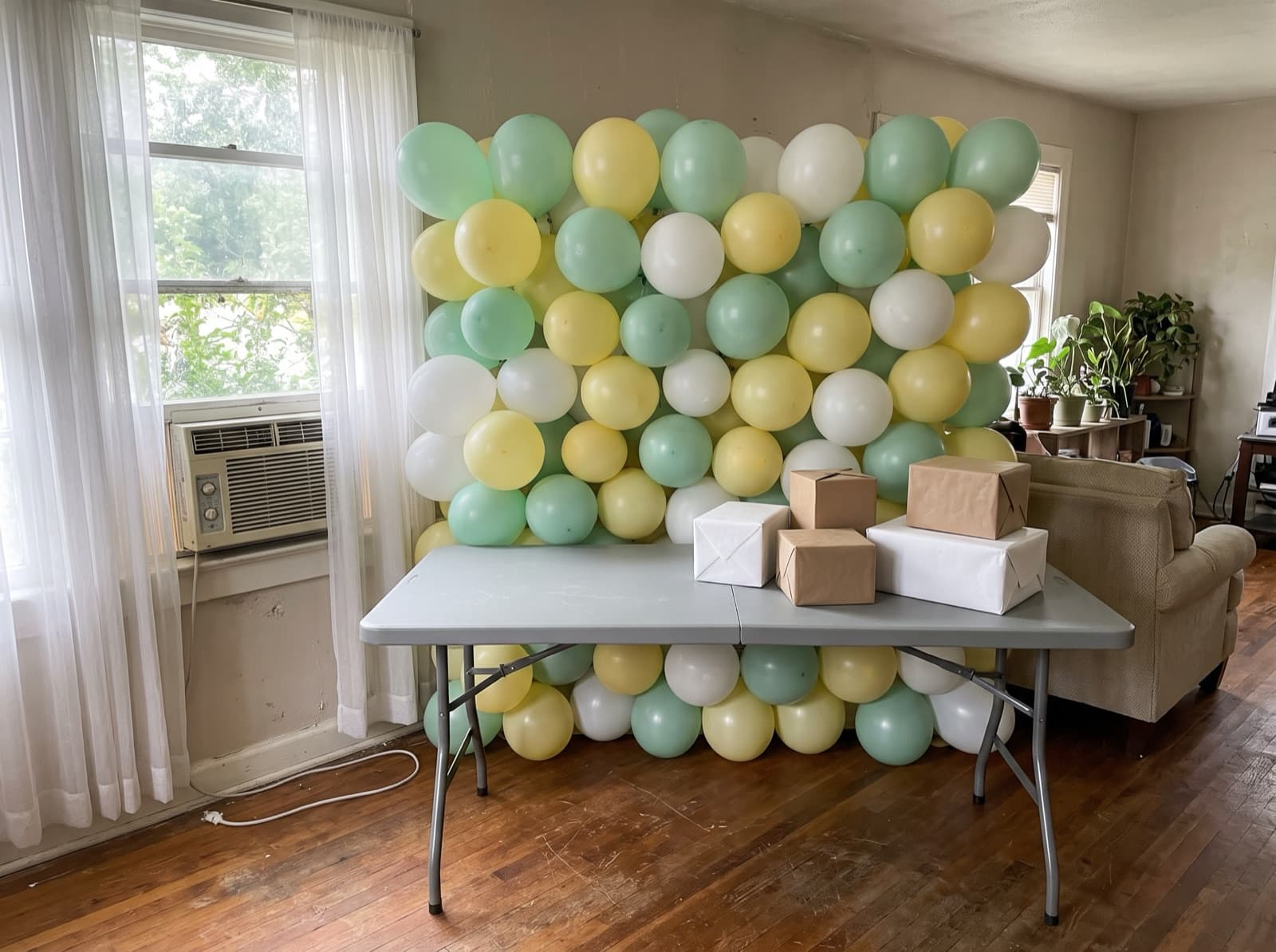 Mint, butter yellow and white balloon wall for a baby shower